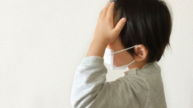 冬に流行する感染症-RSウイルス感染症-マスクをした子どもがしんどそうに額に手を当てている画像